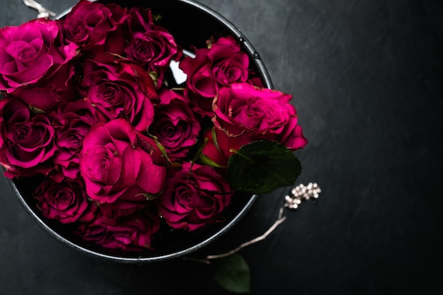 Wyrażenie miłości i romansu. Piękny bukiet czerwonych róż w pudełku na ciemnym tle. Bordowe kwiaty, aby pokazać prawdziwe uczucia
