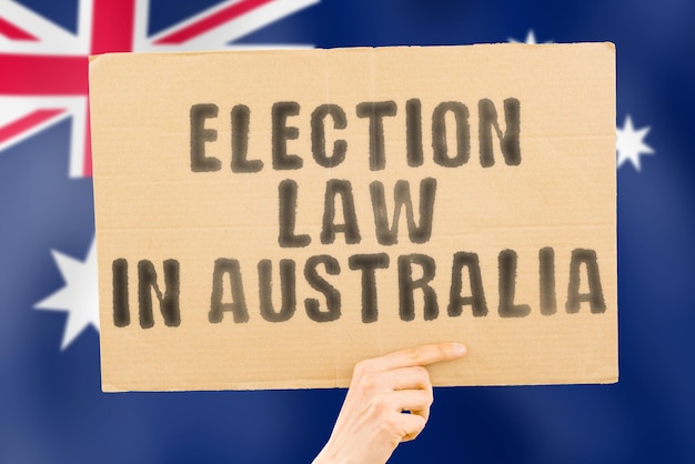 Wyrażenie Prawo wyborcze w Australii na banerze w męskiej dłoni z australijską flagą Konstytucja