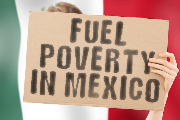 Wyrażenie „Ubóstwo paliwowe w Meksyku” na banerze w męskiej dłoni z zamazaną meksykańską flagą w tle. Gospodarczy. Kosztowny. Przygnębiony. Benzyna. Skamieniałość. Problem. Dostarczać. Kwestie społeczne