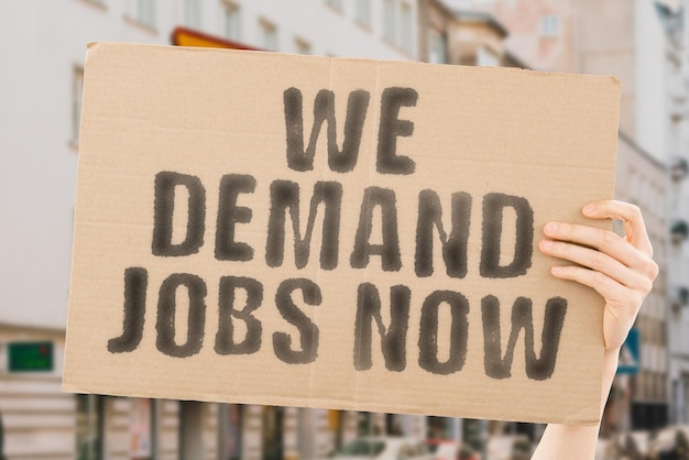 Wyrażenie Żądamy pracy teraz jest na banerze w rękach mężczyzn z rozmytym tłem Ankieta Protest Raport Zasoby Szukaj Zespół strajkowy Badanie Ekonomia Zatrudnij Zatrzymaj Poszukuj