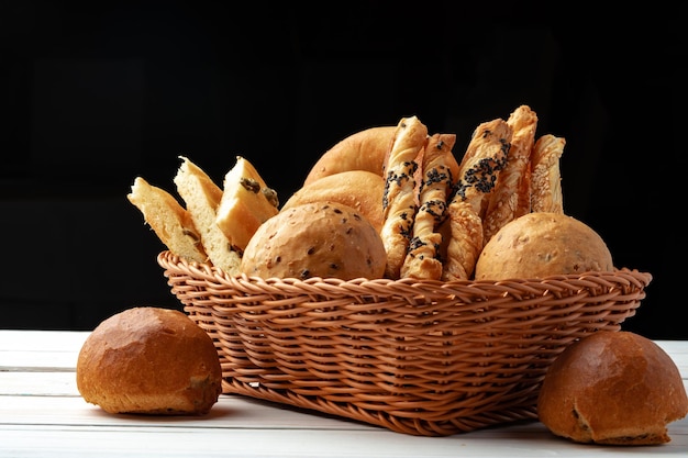 Zdjęcie wyroby piekarnicze w słomianym koszu na chleb na drewnianym stole