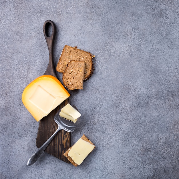 Wyśmienicie holenderski gouda ser z serowymi plasterkami, multigrain chlebem i specjalnym nożem na starej drewnianej desce.