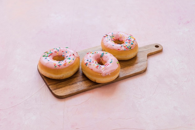 Wyśmienicie Różowi Donuts Z Kropią Na Drewnianej Ciapanie Desce