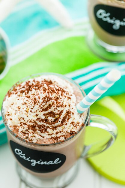 Wyśmienity oryginalny zimny napój czekoladowy przyozdobiony proszkiem kakaowym.