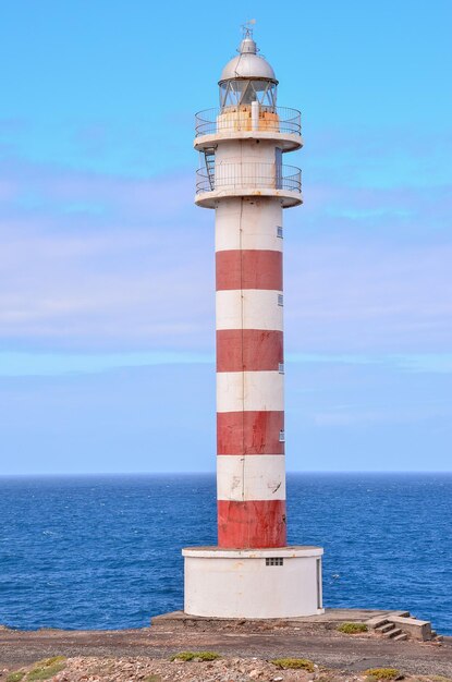 Wysoka latarnia morska w pobliżu wybrzeża na Wyspach Kanaryjskich
