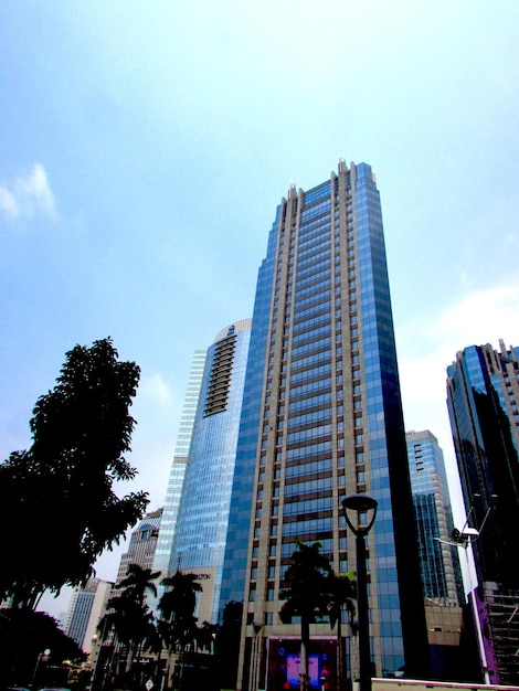 Wysoki budynek z niebieską szklaną fasadą