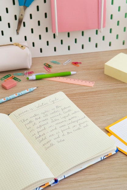 Wysoki kąt biurka dziecięcego z notatnikiem i długopisami