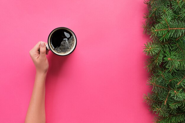 Wysoki kąt kobiety ręce trzyma kubek kawy na różowo