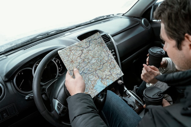 Zdjęcie wysoki kąt mapy konsultacyjnej pary w samochodzie podczas podróży