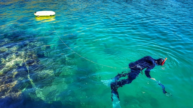 Zdjęcie wysoki kąt widoku człowieka nurkującego w turkusowym morzu