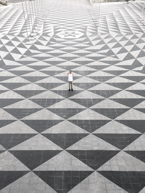 Zdjęcie wysoki kąt widoku człowieka stojącego na płytkowej podłodze