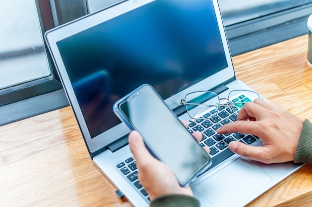 Zdjęcie wysoki kąt widoku człowieka używającego laptopa na stole