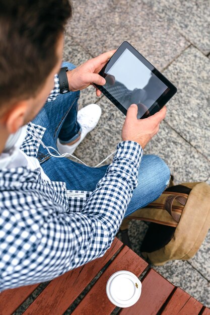 Zdjęcie wysoki kąt widoku człowieka używającego tabletu cyfrowego w mieście