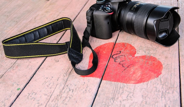 Zdjęcie wysoki kąt widoku kamery dslr w kształcie czerwonego serca na stole