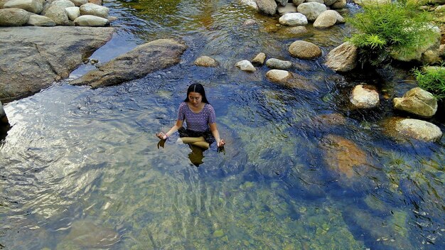 Zdjęcie wysoki kąt widoku kobiety medytującej w jeziorze