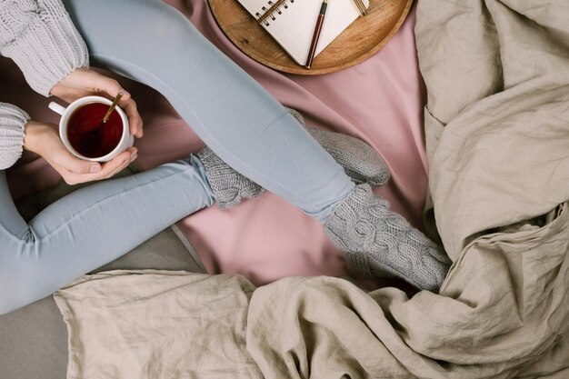 Zdjęcie wysoki kąt widoku kobiety trzymającej filiżankę kawy na łóżku