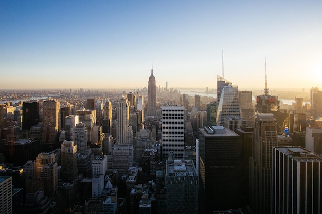Wysoki kąt widoku krajobrazu miejskiego z budynkiem empire state na tle jasnego nieba podczas zachodu słońca