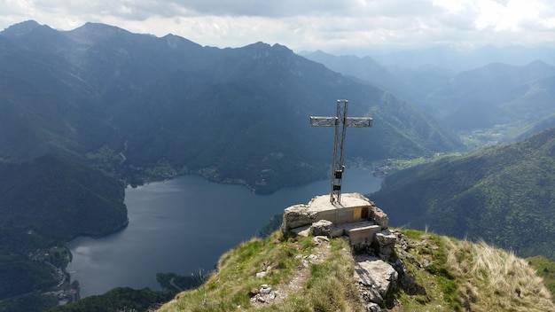 Wysoki kąt widoku krzyża na klifie na tle gór