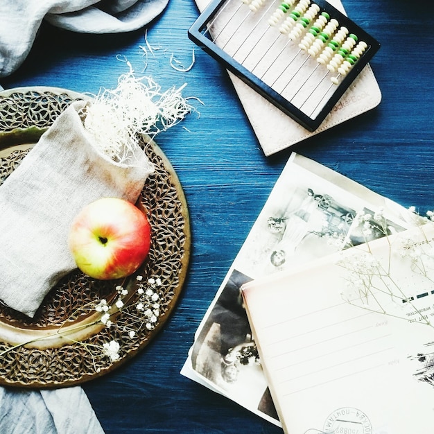 Wysoki kąt widoku książki z jabłkiem i tkaniną na stole