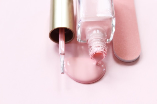 Wysoki kąt widoku lakieru do paznokci z plikiem na różowym tle