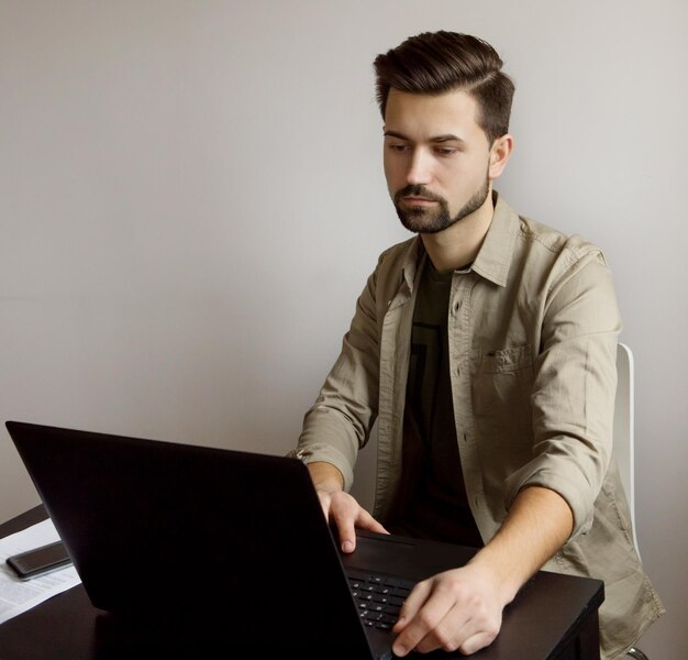Zdjęcie wysoki kąt widoku młodego mężczyzny używającego laptopa na stole w biurze