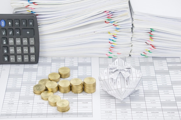 Zdjęcie wysoki kąt widoku monet z pudełkiem podarunkowym i kalkulatorem na dokumentach finansowych