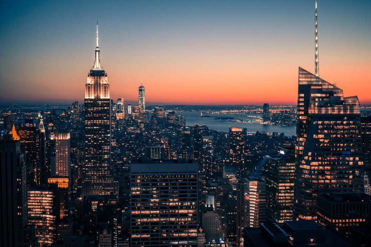 Zdjęcie wysoki kąt widoku oświetlonego budynku empire state building i krajobrazu miejskiego na jasnym niebie w nocy