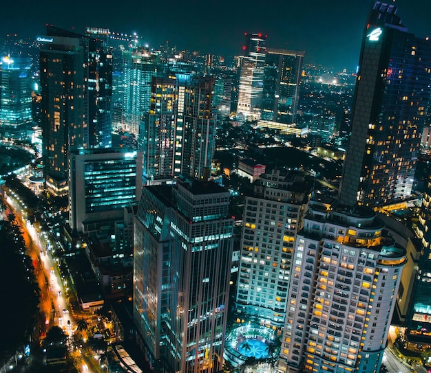 Wysoki kąt widoku oświetlonych nowoczesnych budynków w mieście w nocy