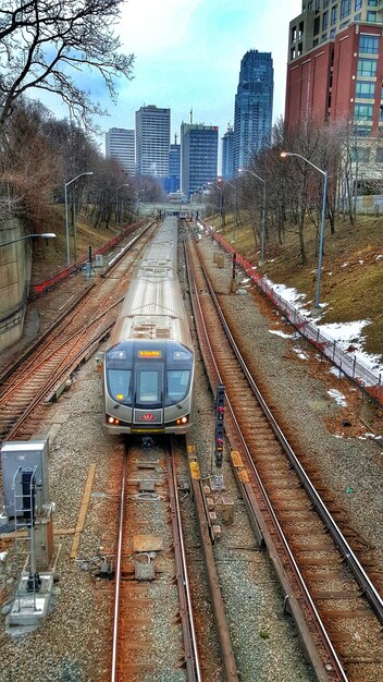 Zdjęcie wysoki kąt widoku pociągu na torze kolejowym w stosunku do budynków