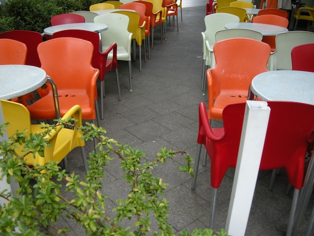 Zdjęcie wysoki kąt widoku pustych krzeseł i stołów w kawiarni na chodniku