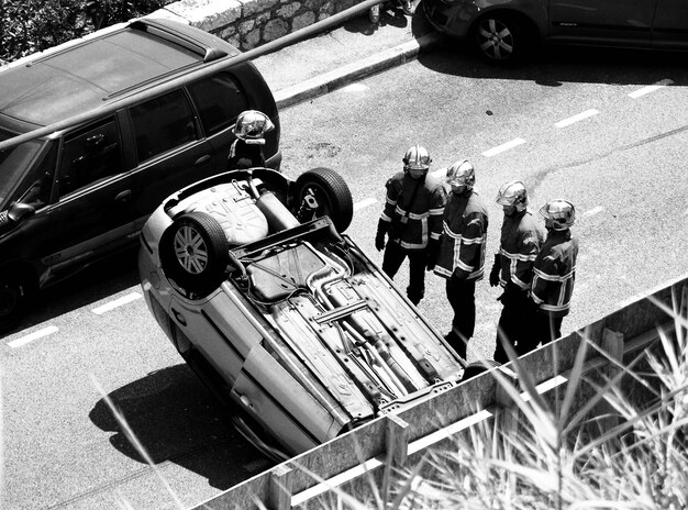 Zdjęcie wysoki kąt widoku ratowników stojących w pobliżu przewróconego samochodu