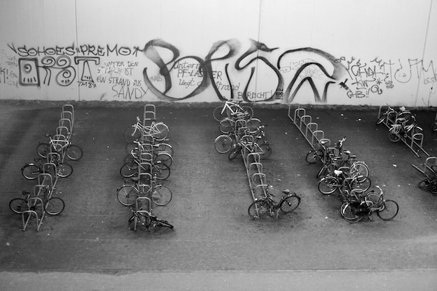 Zdjęcie wysoki kąt widoku rowerów zaparkowanych w stojaku przeciwko graffiti na ścianie