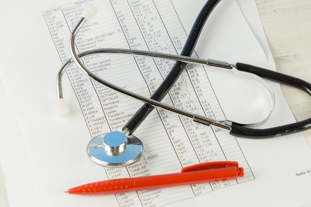 Zdjęcie wysoki kąt widoku stetoskopu z długopisem na sprawozdaniu medycznym przy stole
