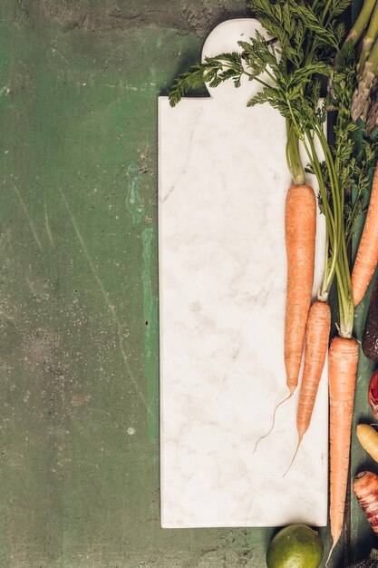 Zdjęcie wysoki kąt widoku warzyw i ziół z deską do cięcia na stole