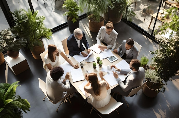 Wysoki kąt widzenia biznesmenów siedzących przy stole podczas spotkania w biurze
