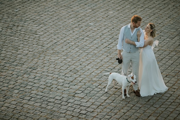 Wysoki kąt widzenia uroczej młodej pary nowożeńców z psem Jack Russel Terrier