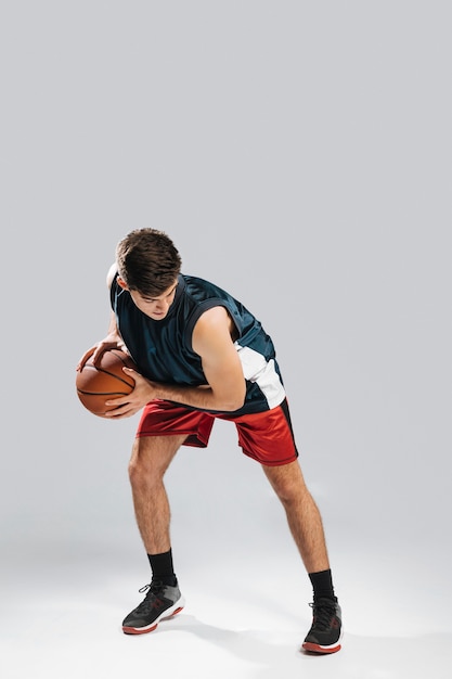Zdjęcie wysoki mężczyzna gra w koszykówkę sam