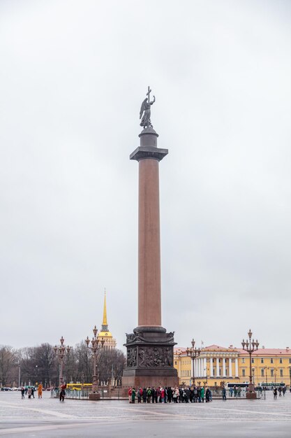 Wysoki posąg kobiety z posągiem stoi przed budynkiem.