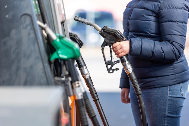 Zdjęcie wysokie ceny benzyny i oleju napędowego na stacji paliw młoda kobieta tankuje samochód ekonomiczny