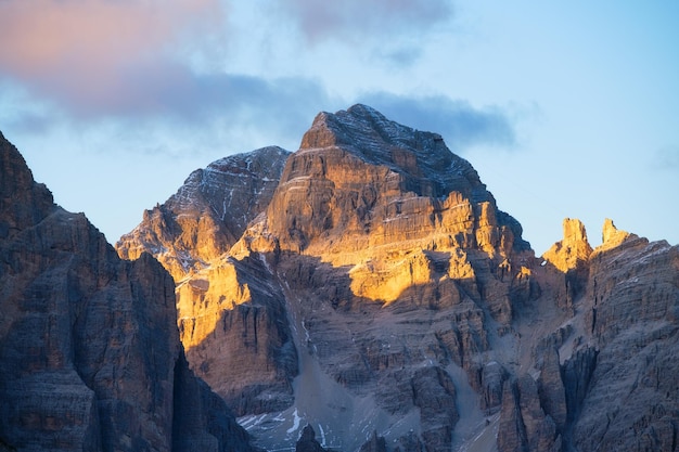 Wysokie skały podczas zachodu słońca Dolomity Alpy Włochy Góry i pochmurne niebo Widok na góry i klify Naturalna górska sceneria Fotografia jako tło dla podróży