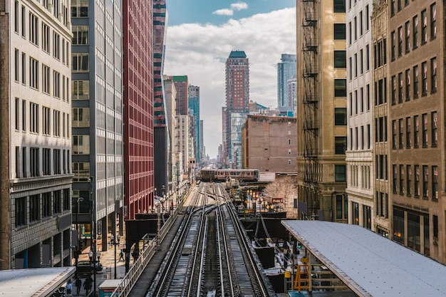 Wysokie tory kolejowe biegną nad torami kolejowymi między budynkiem na linii Loop w Chicago, Illinois, USA