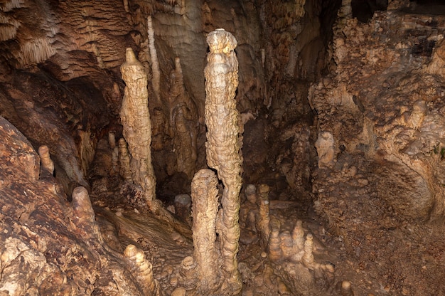 Wysoko mineralne stalagmity w ciemnej jaskini