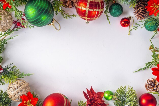 Wysokokolorowe tło Bożego Narodzenia i Nowego Roku z gałęziami choinki, dekoracjami bombek ze świerku jodłowego i kwiatami bożonarodzeniowymi, widok z góry, przestrzeń kopiowania