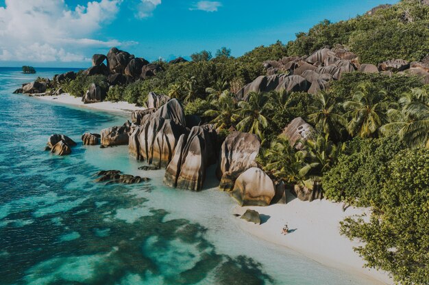 Wyspa „La digue” na Seszelach. Srebrna plaża z granitowym kamieniem i dżunglą. Mężczyzna cieszy się wakacje i relaksuje na plaży. Widok z lotu ptaka