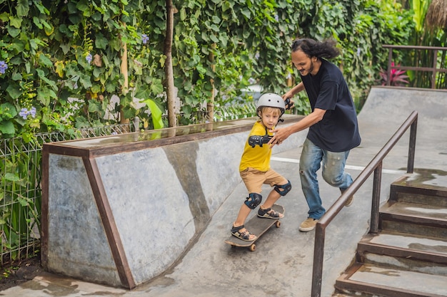 Wysportowany chłopiec uczy się jeździć na deskorolce z azjatyckim trenerem w skateparku Edukacja dzieci Sport Różnorodność ras