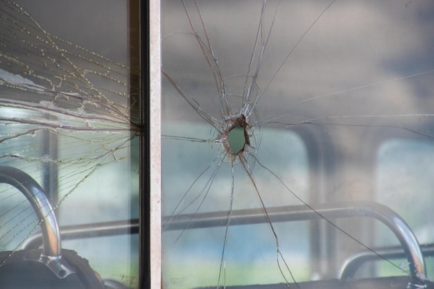 Wystrzał w oknie autobusu z dziurą po kuli i rozbitym szkłem