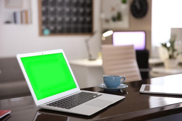 Wyświetlacz laptopa z kluczem chrominancji na biurku w pokoju Wygodne miejsce pracy z nowoczesnym komputerem