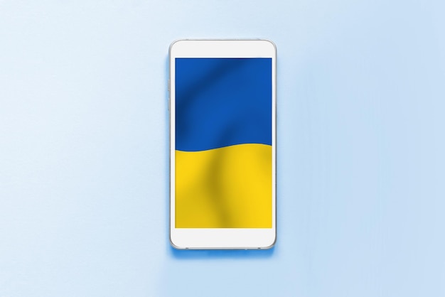 Wyświetlacz smartfona z ukraińską flagą na białym tle na szarym tle Kopiowanie miejsca Ukraińskie symbole Tapeta