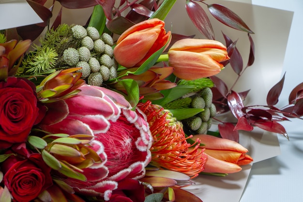 Wyszczególnia zbliżenie wspaniałego bukiet tulipan, leucospermum, leucadendron, protea, róża, selekcyjna ostrość