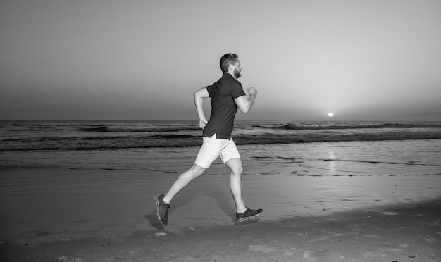 Wytrzymałość i wytrzymałość sprinter jogging sport sportowiec biegnij szybko, aby wygrać w morzu zachód słońca rano trening aktywność zdrowy mężczyzna bieganie na wschodzie słońca plaża energiczny letni biegacz poczuj wolność pospiesz się